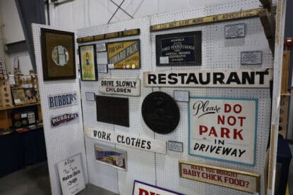 Antique signs for sale that are for rubbers, parking, work clothes and restaurants.