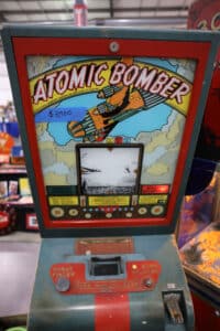 Vintage Atomic Bomber coin-operated arcade game with bomb sight viewer and colorful WWII-era graphics.
