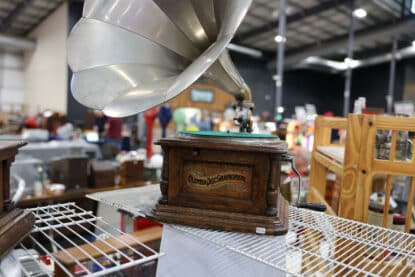 Antique Columbia Disc Graphophone with large metal horn and wooden case displayed on a vintage show table.