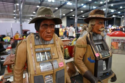 Highly detailed Native American and Cowboy themed slot machine figures with coin mechanisms, displayed at the Chicagoland Antique Coin-Op Show.
