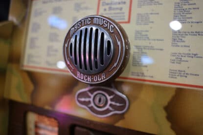 Close-up of the Rock-Ola Mystic Music jukebox microphone-style grille with engraved text.