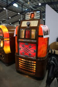 Full view of a Rock-Ola Mystic Music Super jukebox with glowing pilasters and decorative grille.