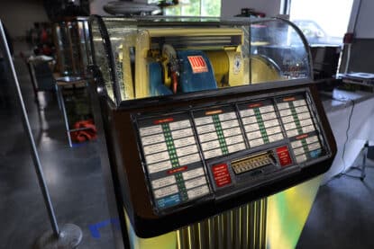 Vintage Seeburg Select-O-Matic jukebox with yellow and blue mechanism and 100 record selections.