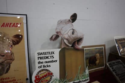 Vintage Sweetlix advertising sign with a three-dimensional cow tongue display promoting livestock feed supplements at the Chicagoland Coin-Op Show.