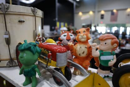Vintage advertising mascot figurines including the Green Giant Sprout, Curad kid, Tony the Tiger, and other cereal and medical brand characters at the Chicagoland Coin-Op Show.