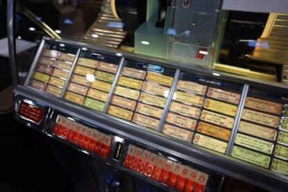 Close-up of a vintage jukebox song selector with alphabet and numeric buttons.
