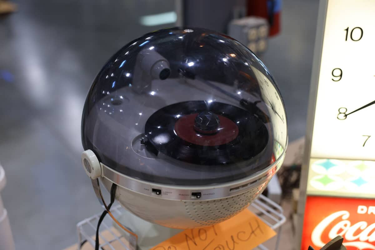 Vintage space-age turntable with a clear acrylic dome and built-in speaker, featuring a 45 rpm record, displayed at the Chicagoland Coin-Op Show.