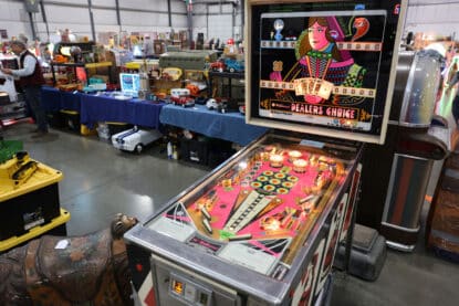 Vintage Williams Dealer’s Choice pinball machine with colorful backglass and lit-up playfield at an antique show.