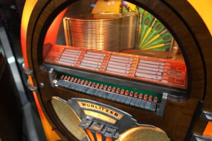 Close-up of the Wurlitzer 1015 jukebox selection panel and illuminated record carousel at a collector's event.